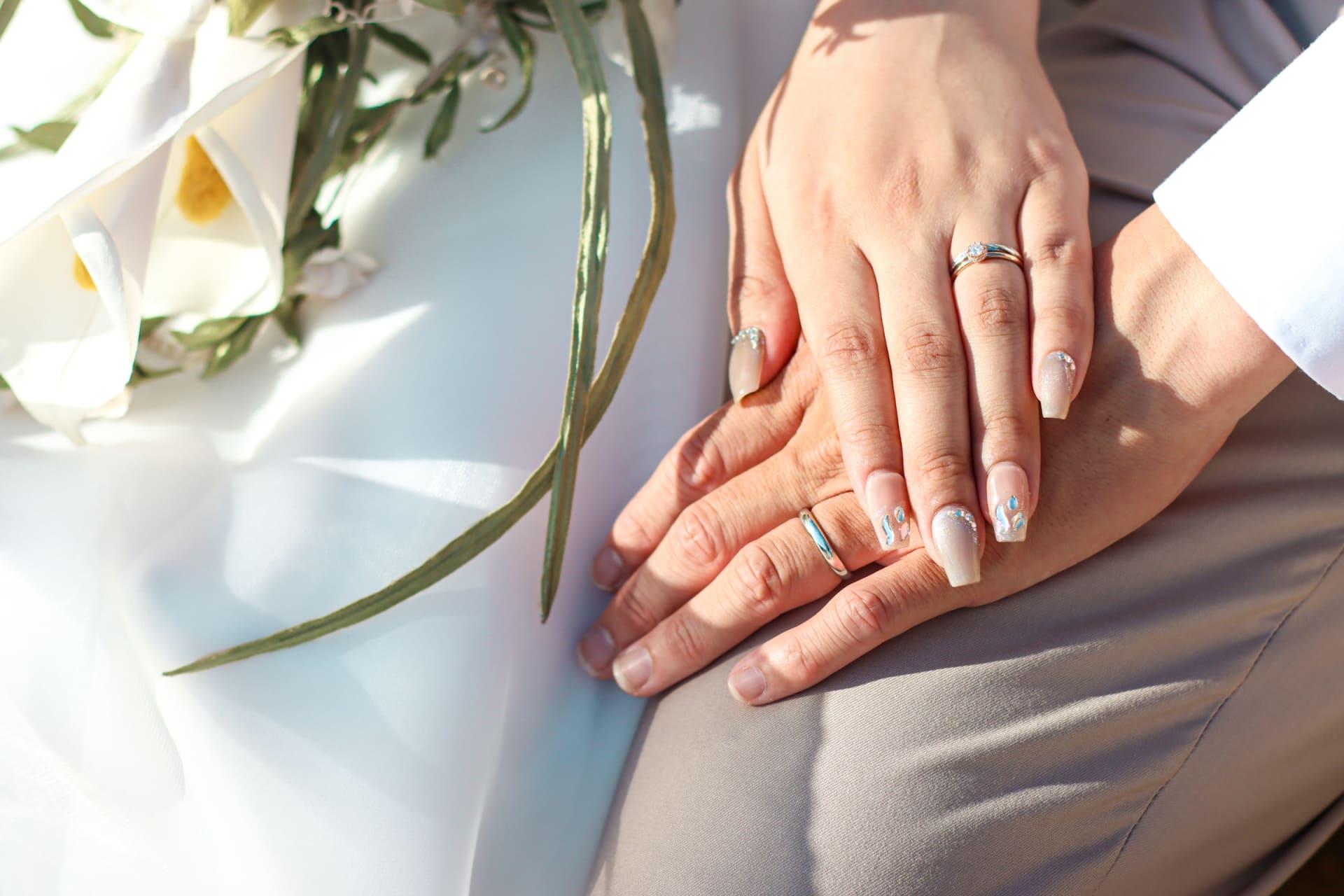 結婚指輪を着けて手を重ねる夫婦