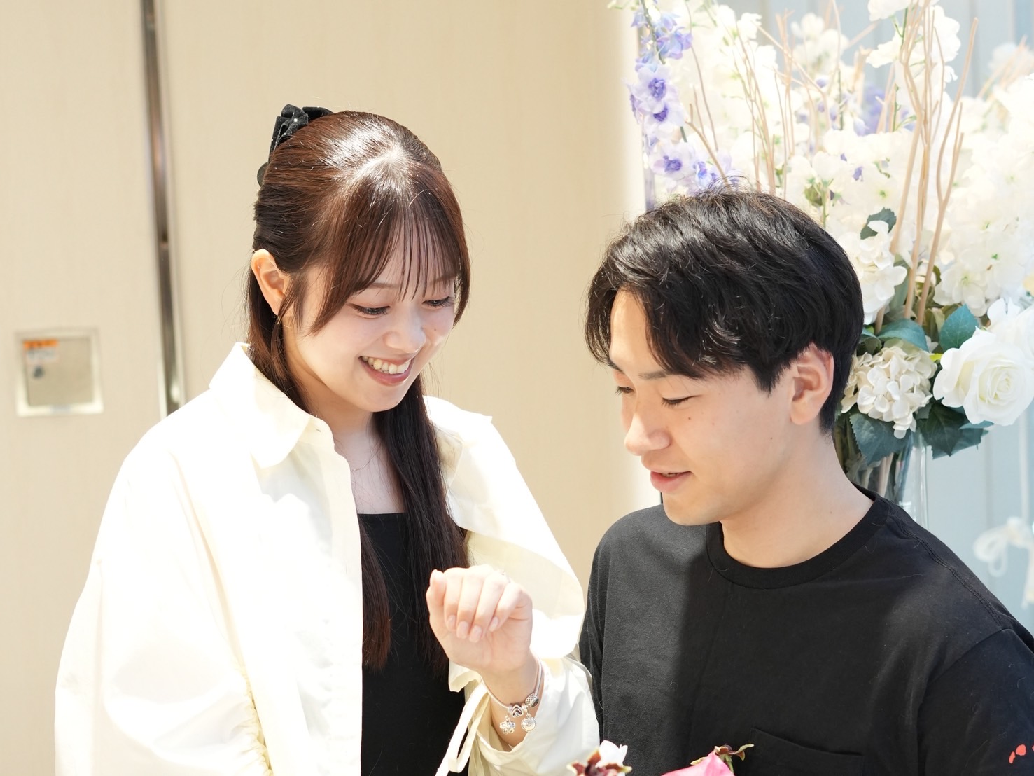 エルサカエ金澤本店でNIWAKAの結婚指輪・マリッジリングを選び、指輪を見つめながら幸せそうに微笑むカップル|金沢で人気のブライダルリング