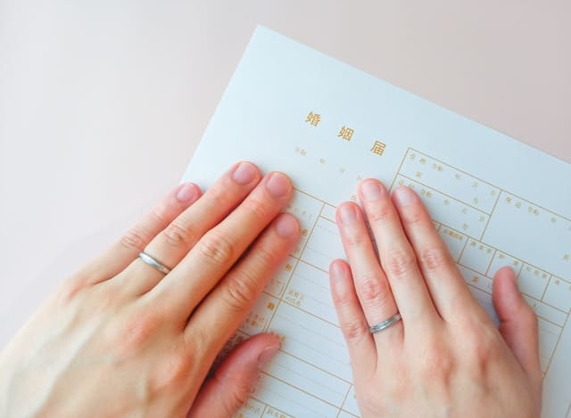 婚姻届けと指輪をつけた手元