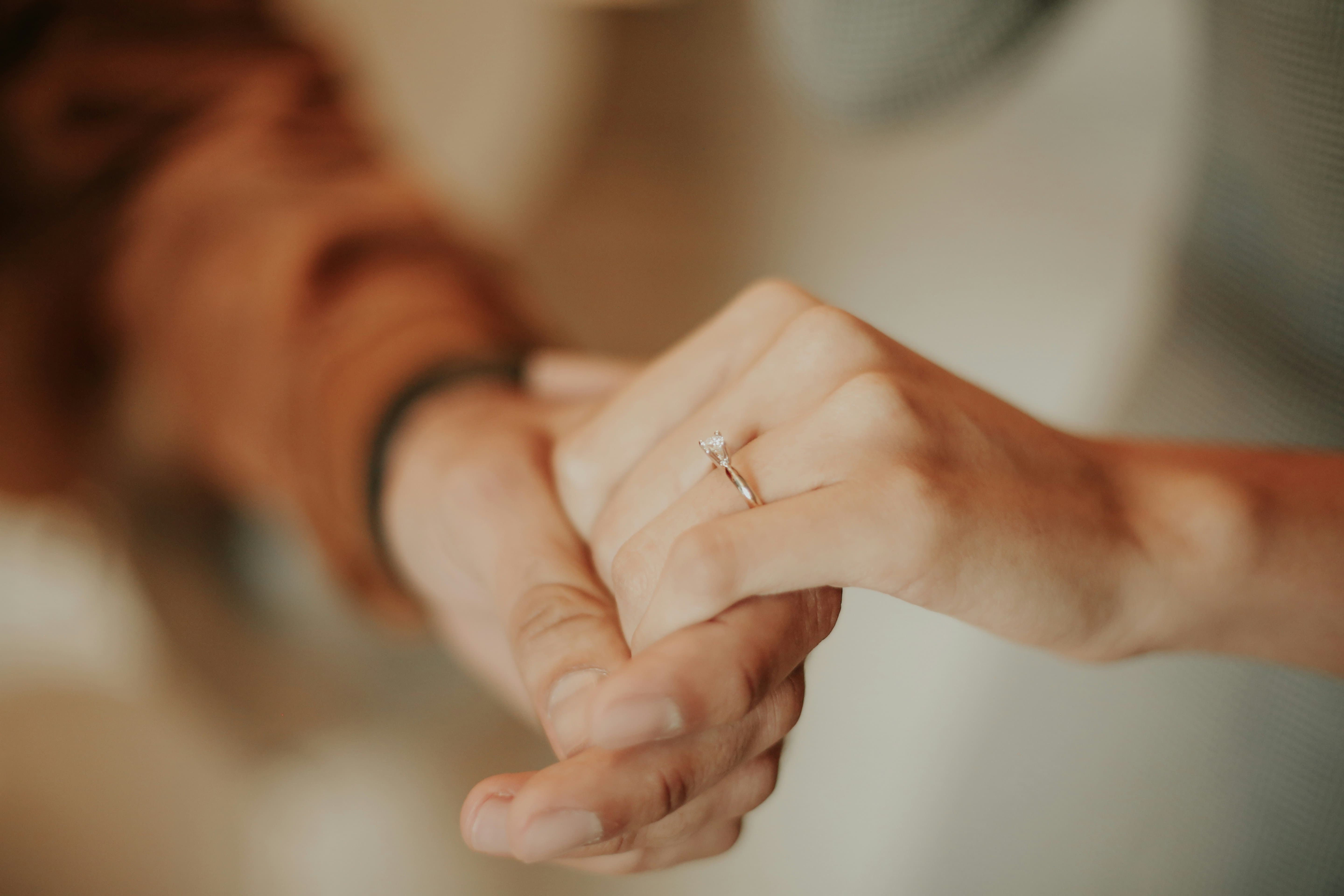 婚約指輪をつけて男女が手を繋いでいる様子