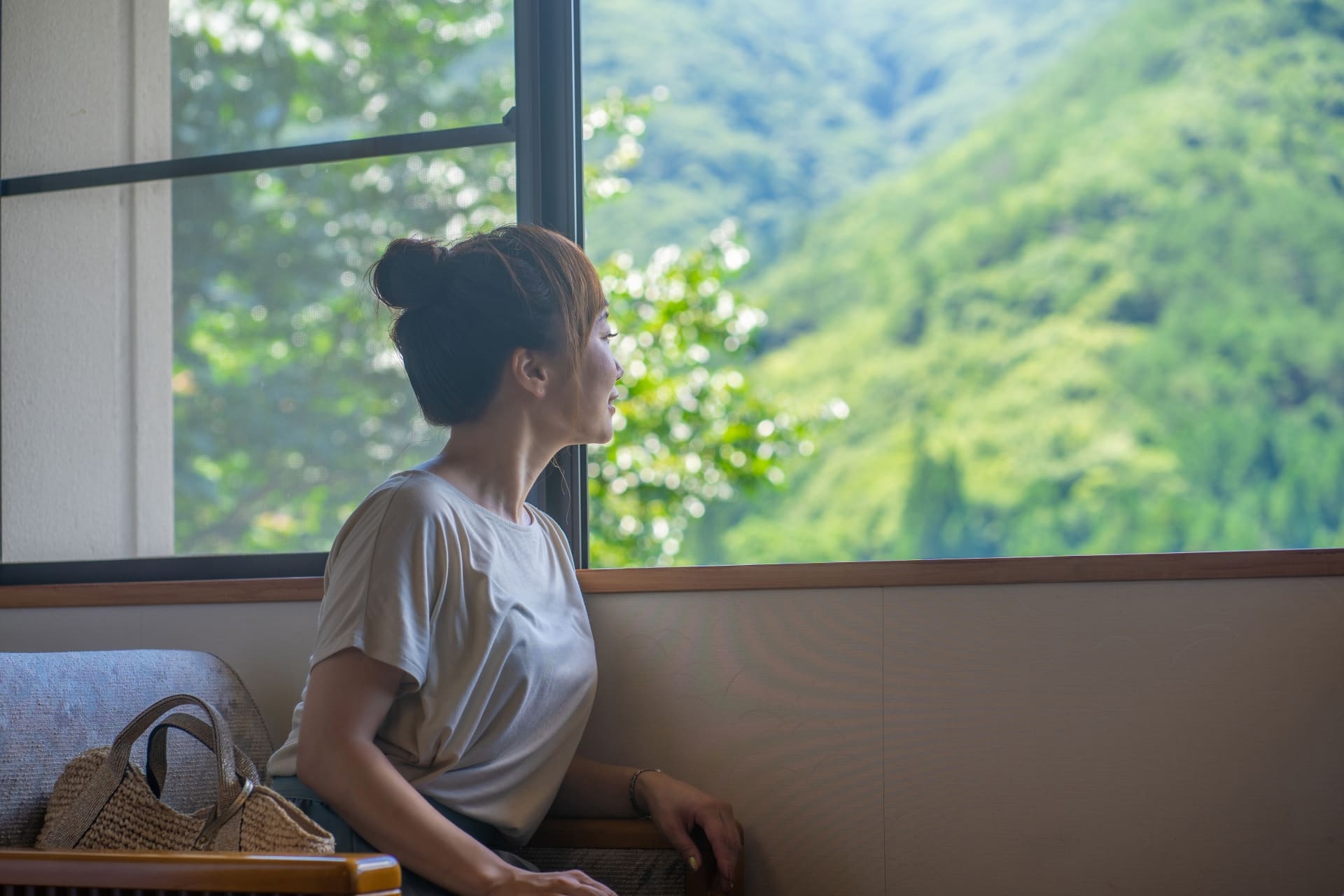 旅館で窓から外を眺める女性