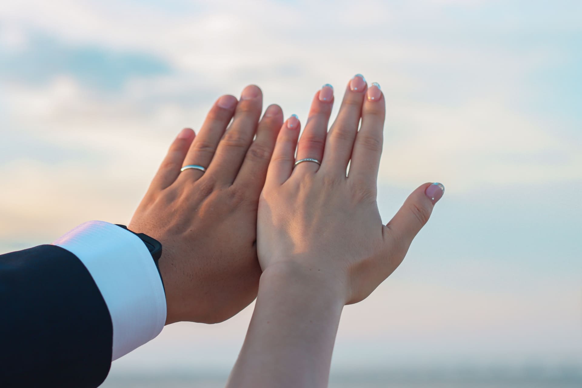 結婚指輪を着けて手を重ねる男女